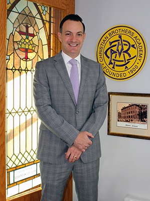 private school website design image of cba president standing in front of cba logo