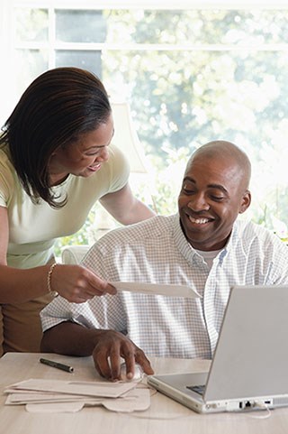 ada compliant website design image of couple looking over bills and paperwork while on laptop