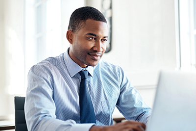 bank website design image of man on computer smiling to visually represent online loan application for fulton savings bank by acs web design and seo