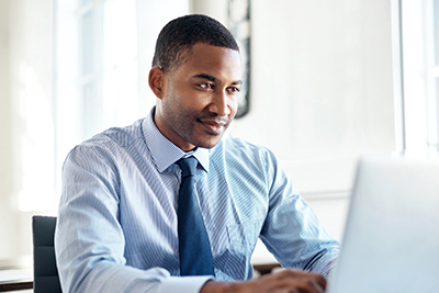 nursing home website design image of smiling man looking at laptop