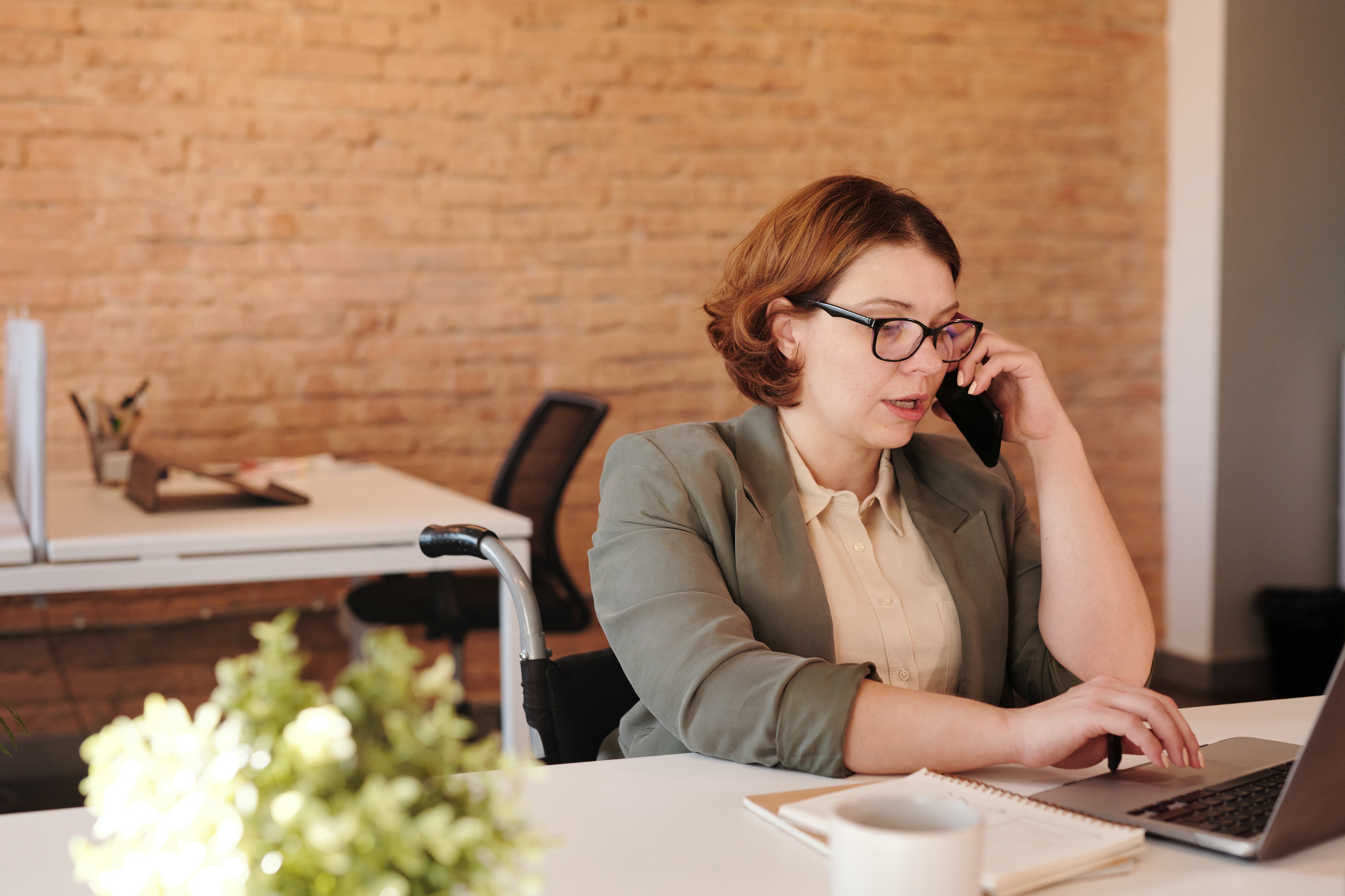 instagram business page image of white collar professional at desk on laptop and talking on phone