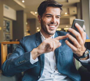 image of man smiling and tapping button on phone on real estate web design