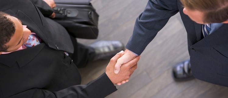 image of people in suits shaking hands representing lead generation from real estate web design