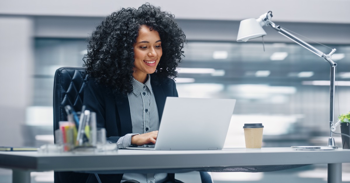 contractor website design woman smiling while using laptop to make website updates