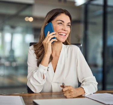 a website builder may cost more than custom web design business owner smiling on the phone